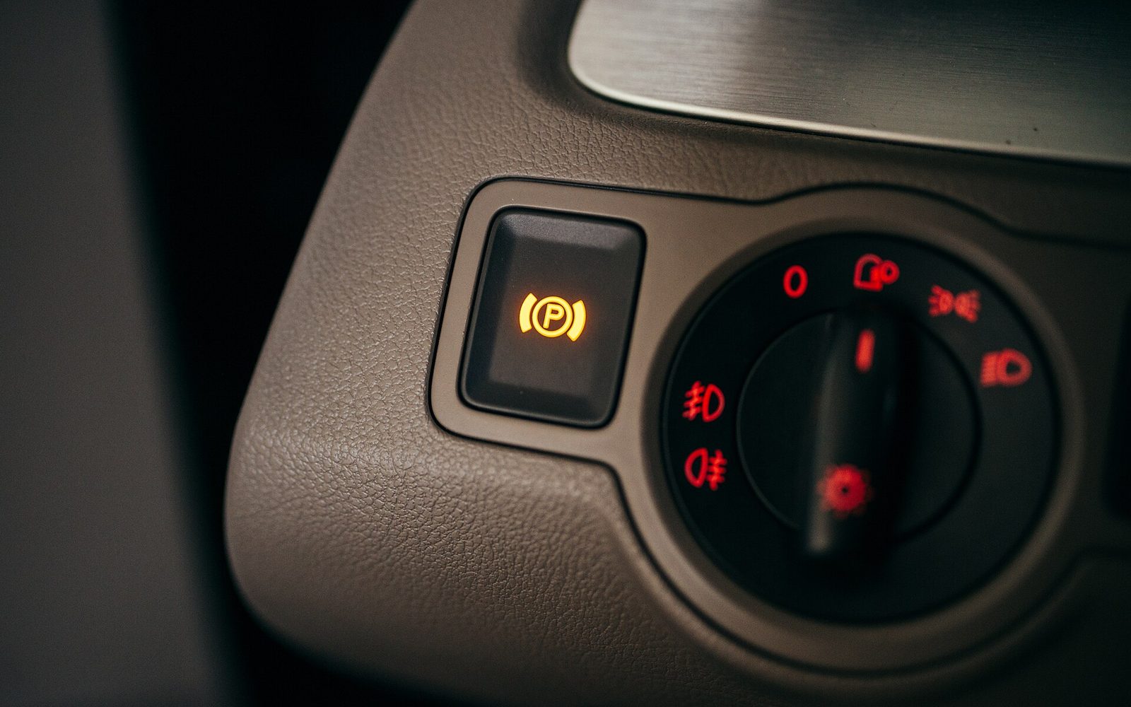 An amber warning light glowing on a car dashboard at night